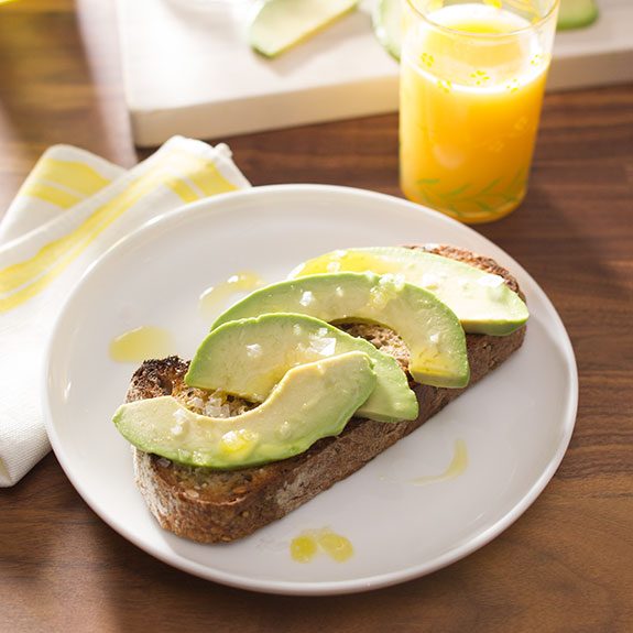 Toast with slices of avocado and topped with salt and olive oil