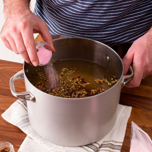 large metal pot filled with water and seasonings