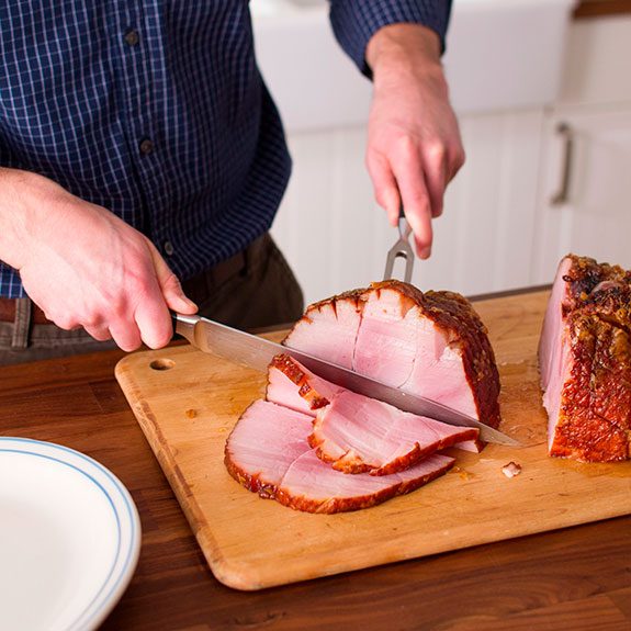 person cutting slices from the cushion of the meat