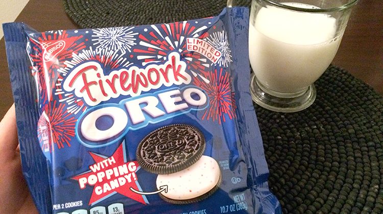 A brand new package of firework oreos beside a glass of milk