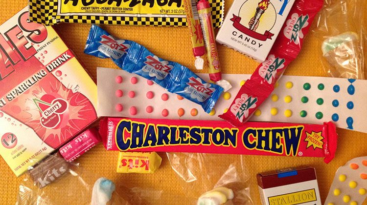 Multiple types of old-fashioned candy spread out on a yellow tablecloth