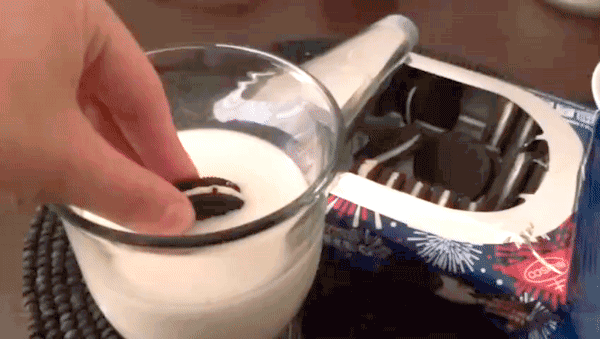Firework oreo being dunked repeatedly into a glass of milk