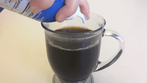 Animation of person pouring the instant latte into a cup of coffee that bubbles, swirls, and lightens in color
