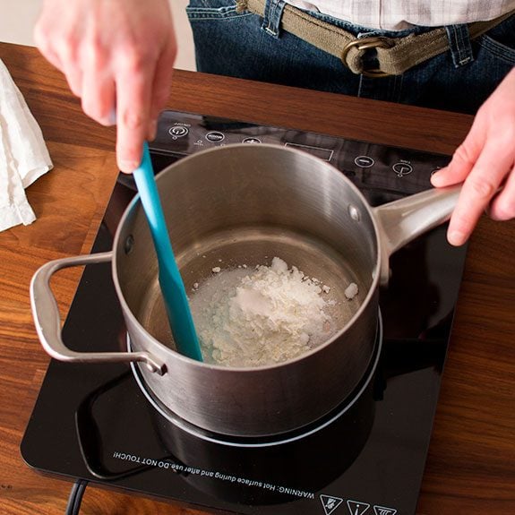 Sugar, cornstarch, and salt being mixed together in a large saucepan