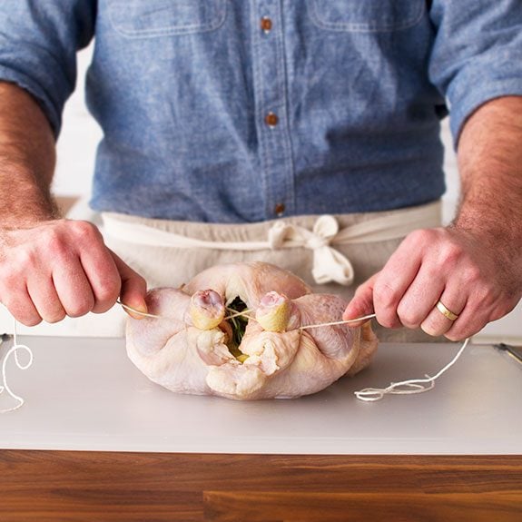 Person pulling the string tight and causing the chicken parts to squeeze together